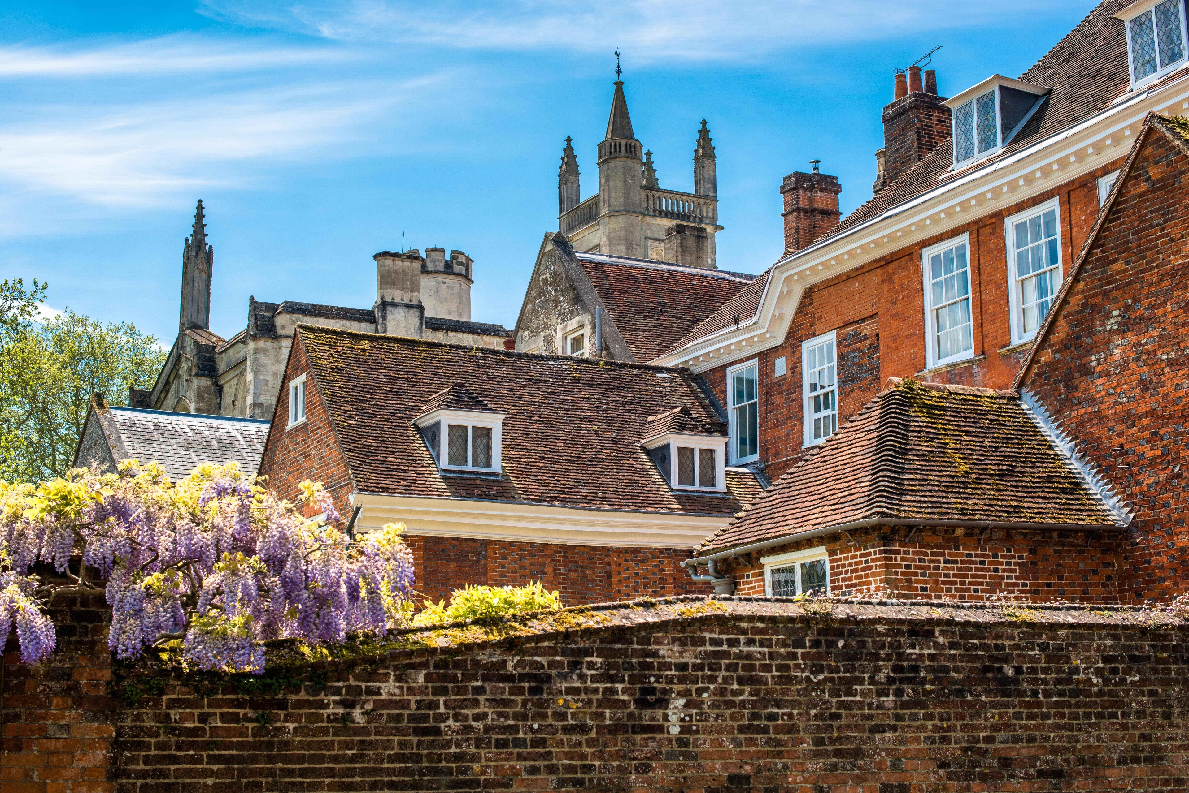 A grand redrbick building, the Warden's Lodgings, sits as part of Winchester College's quaint architecture.